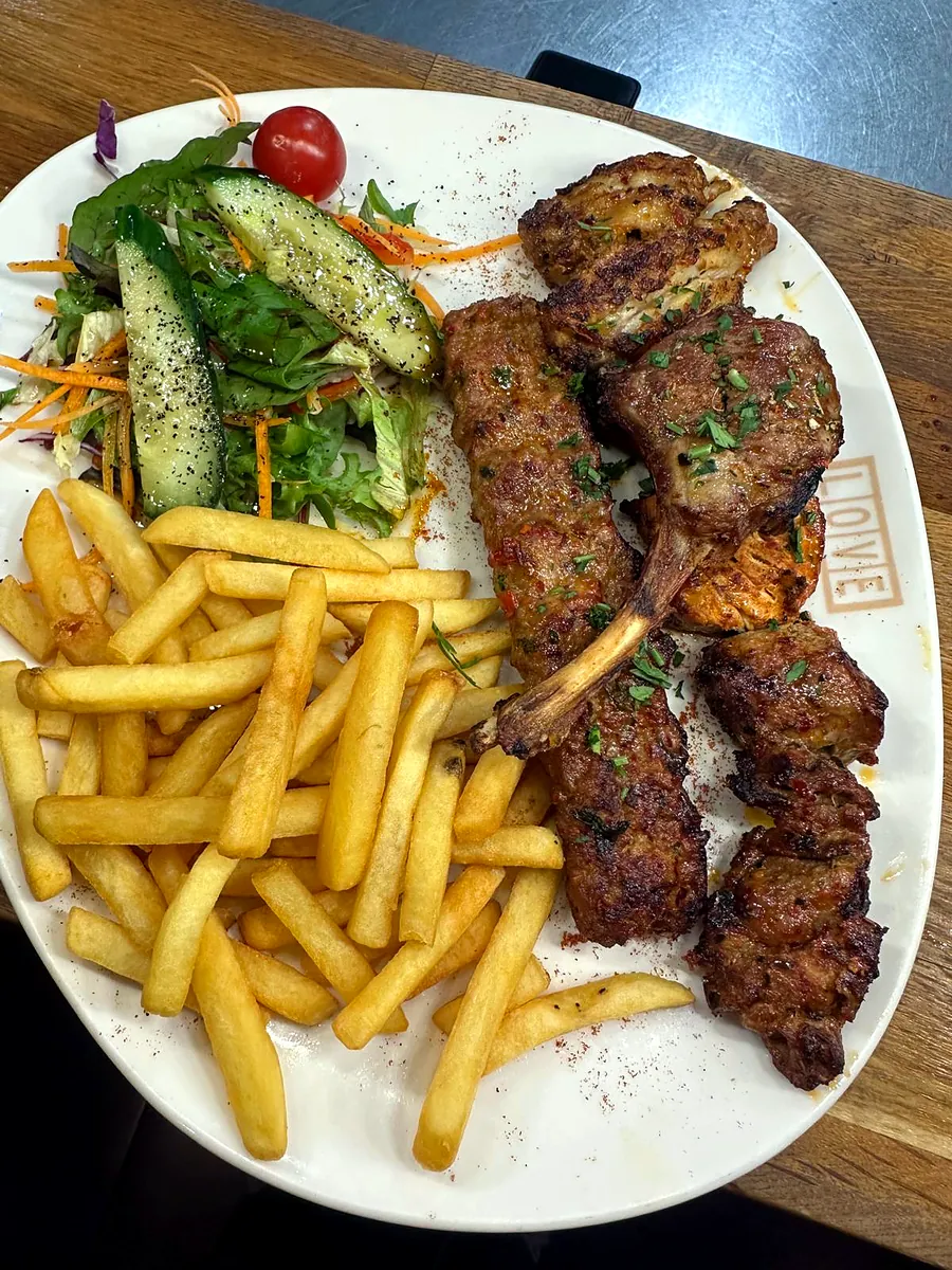 Charcoal-grilled cutlets with chips and a fresh side salad
